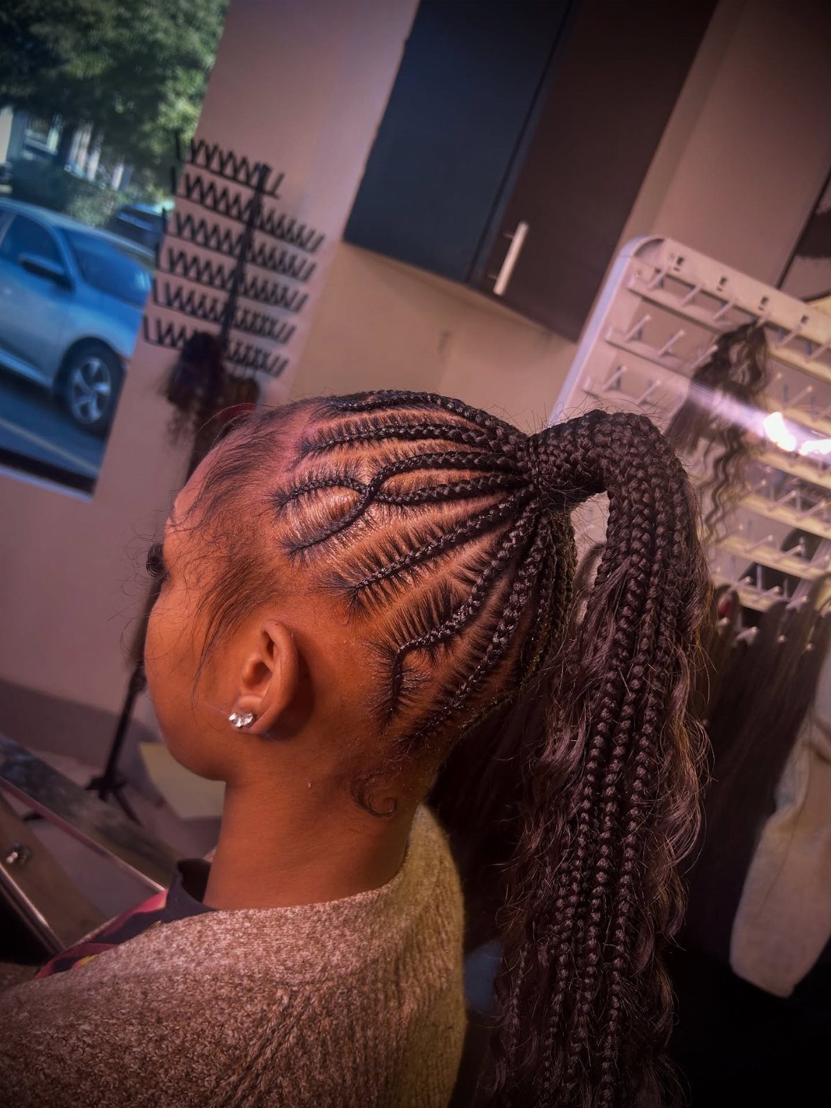 High braided ponytail with intricate cornrow patterns on the scalp and long braids.