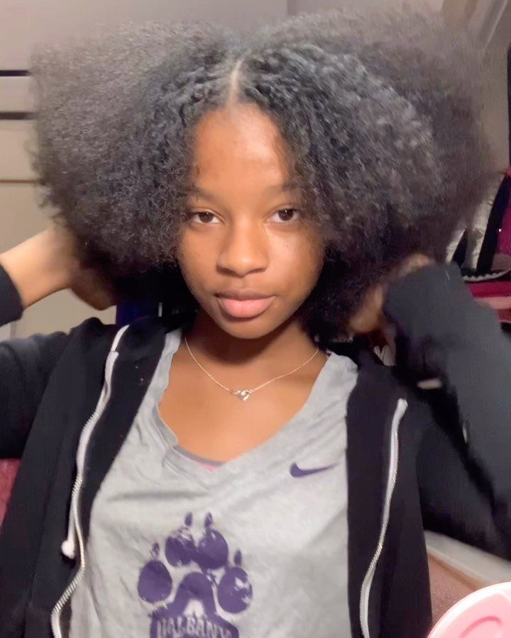 Young woman with voluminous, fluffy black afro hair posing for a portrait.