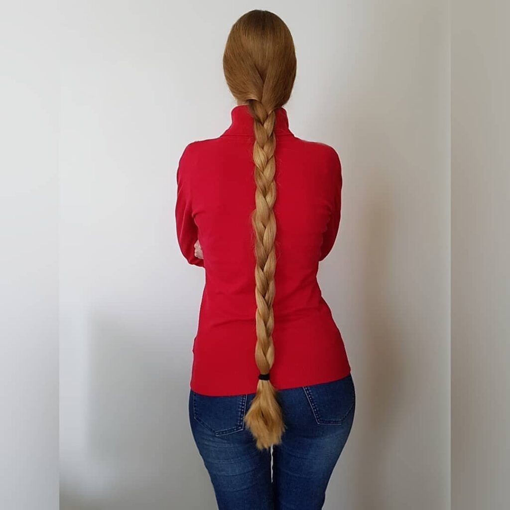 Long blonde hair styled in a classic three-strand English braid down the back