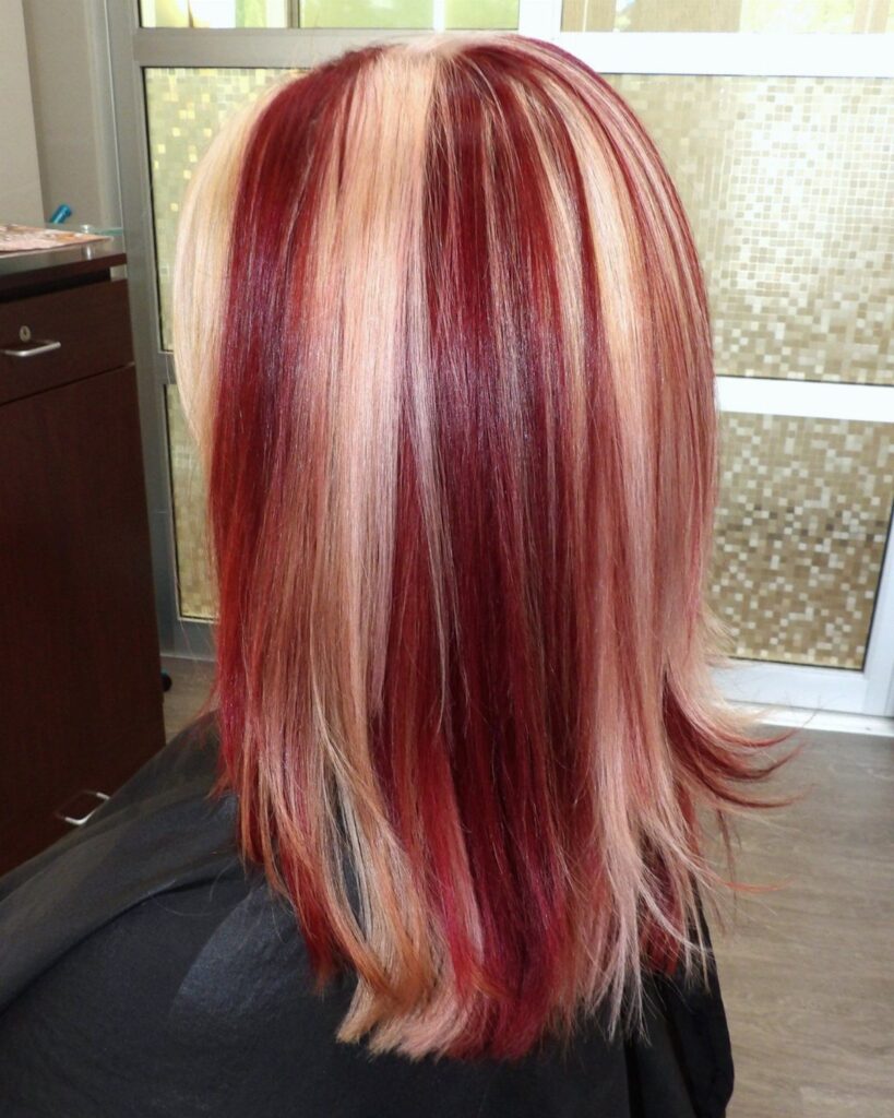 Shoulder-length hair with alternating thick streaks of deep red and pale blonde colors.