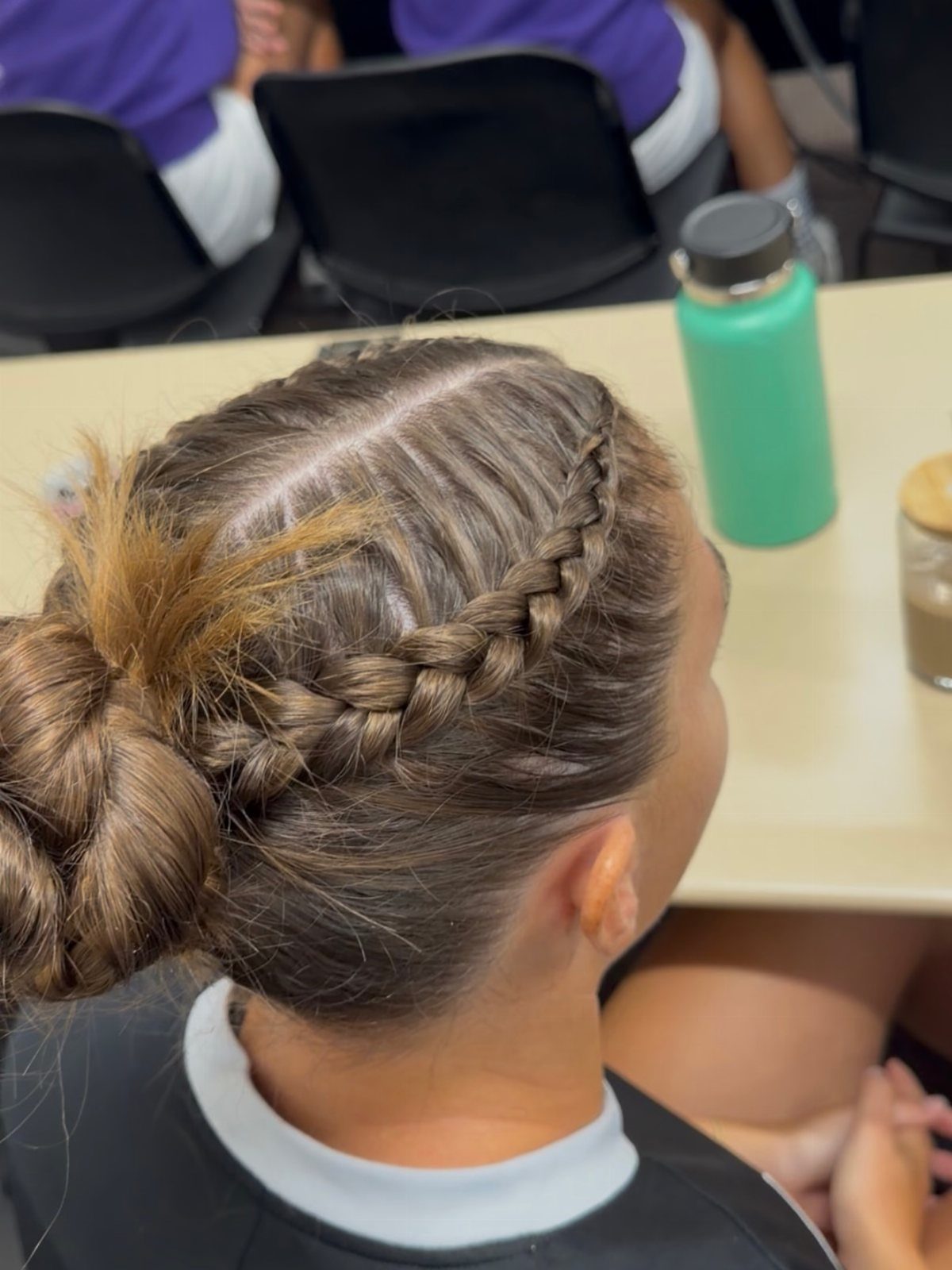 Braided hairstyle with a side Dutch braid and a low braided bun.