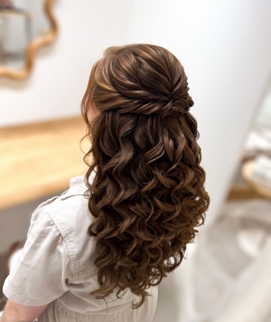 Brown curly hair styled in a half-up crown twist with loose cascading curls.