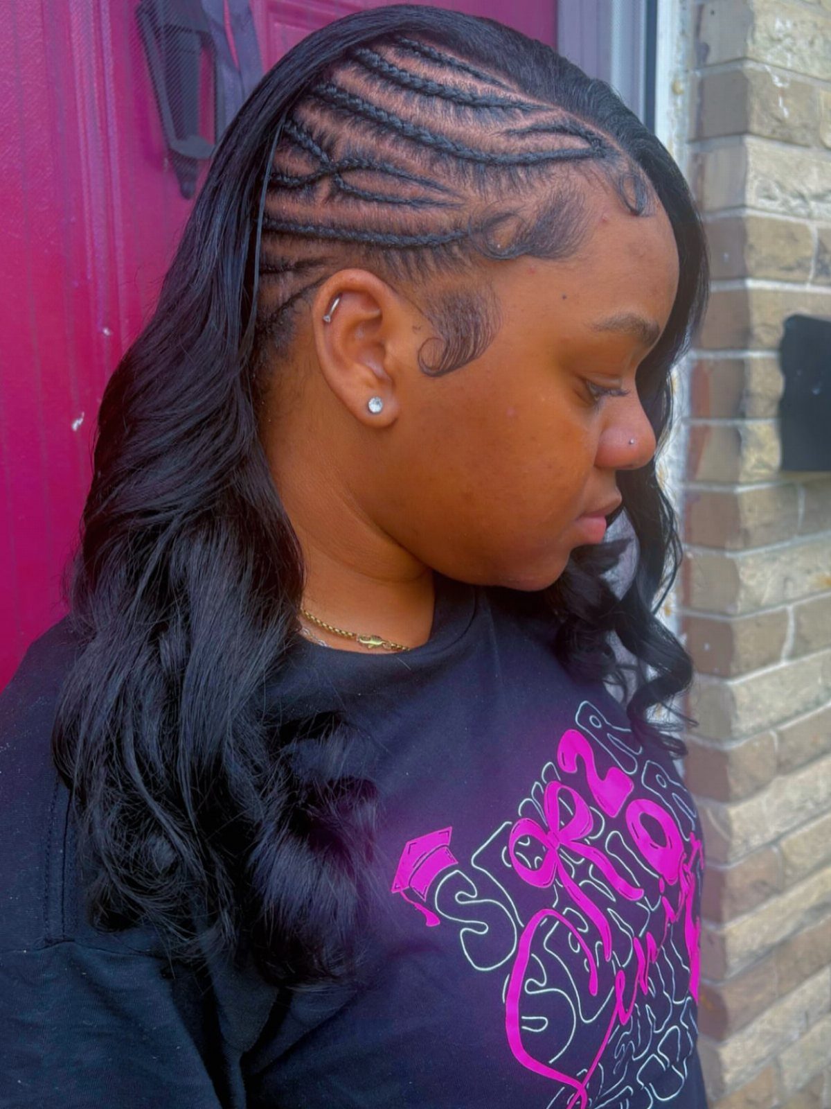 Woman with black hair featuring side cornrow braids and long loose curls.