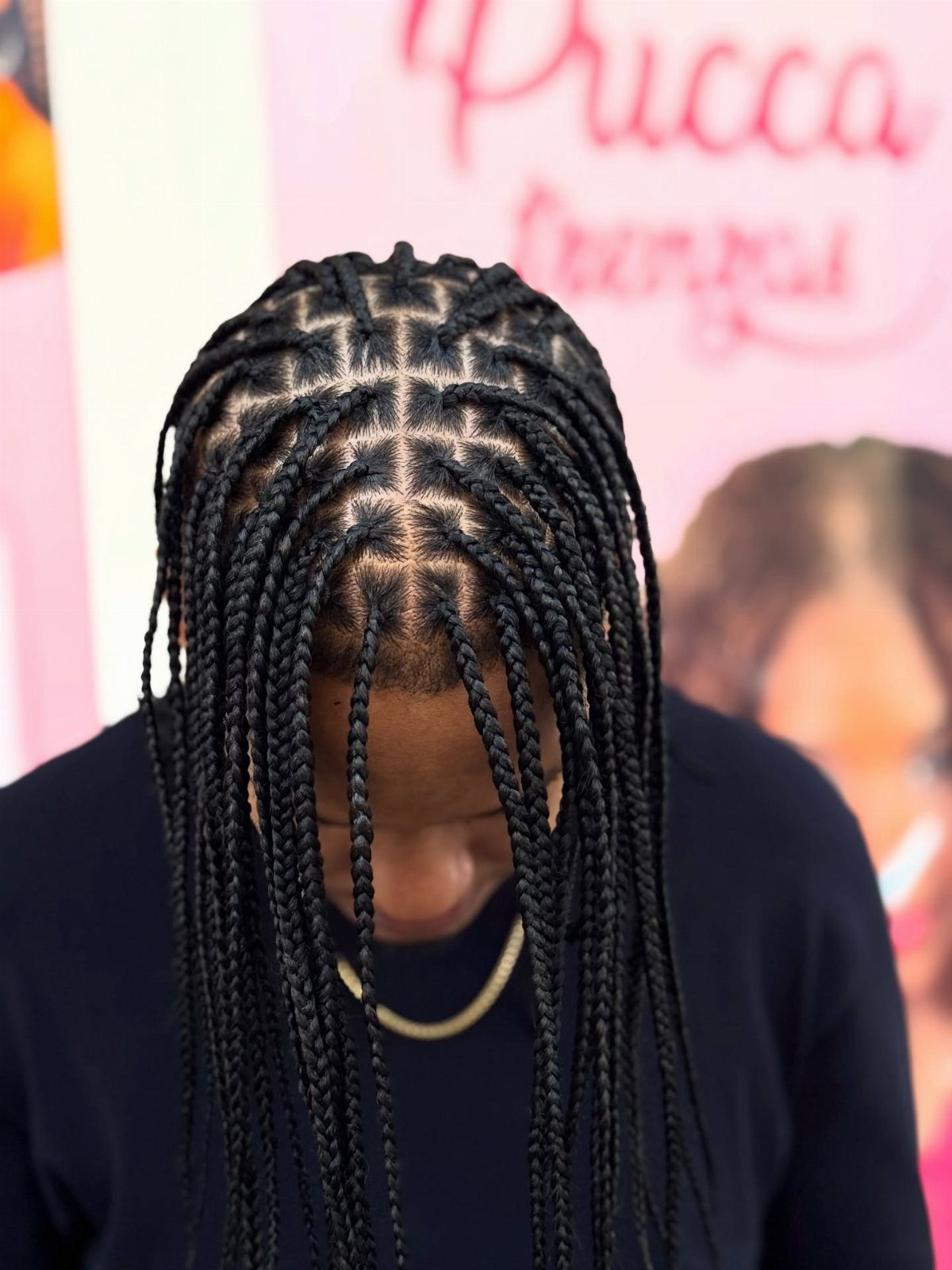 Man with black knotless braids styled in a precise grid pattern on scalp