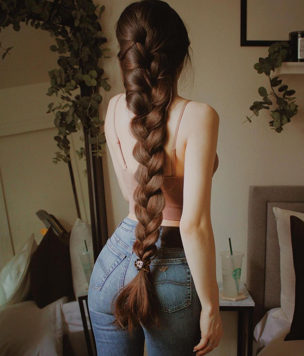 Woman with long brown hair in a thick, voluminous braid down her back