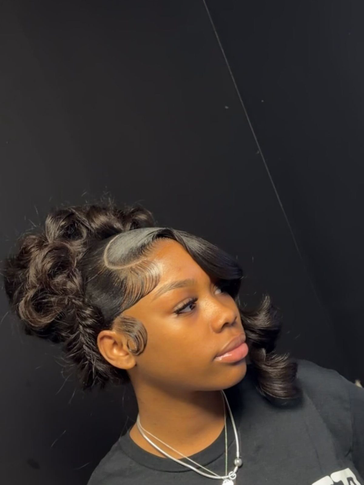 Woman with dark hair styled in voluminous retro curls and a structured updo.