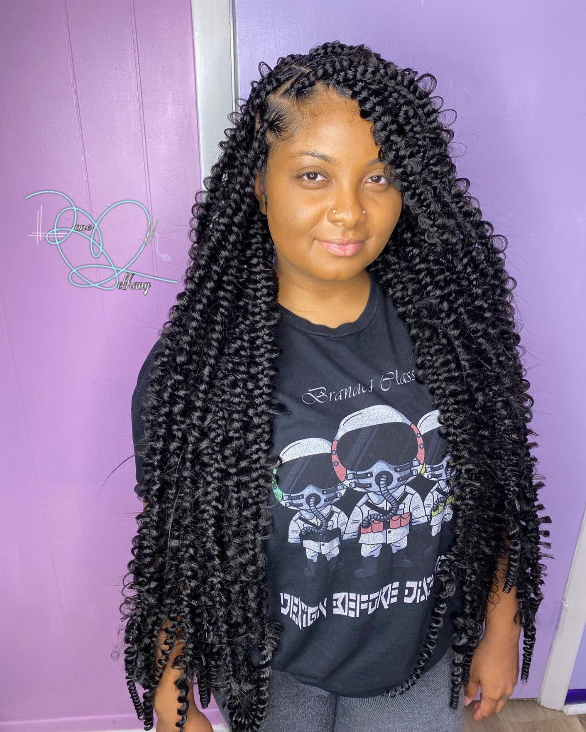 Woman with long black bohemian braids and curly ends against a purple background